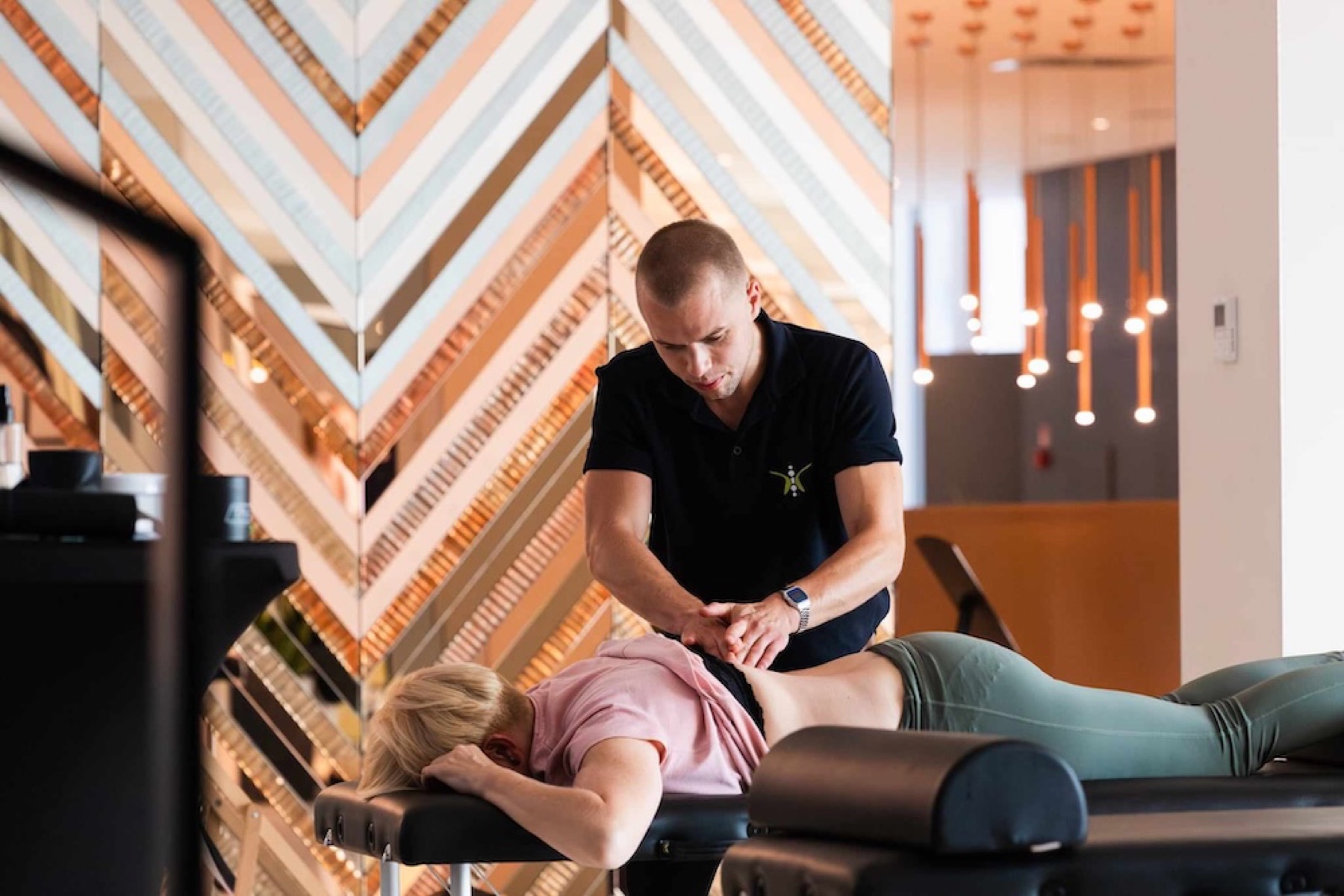 Fizjoterapeuta pracuje z pacjentem na stole terapeutycznym na miejscu