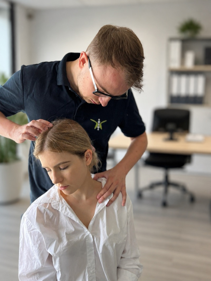 Fizjoterapeuta wykonuje terapię manualną karku w biurze
